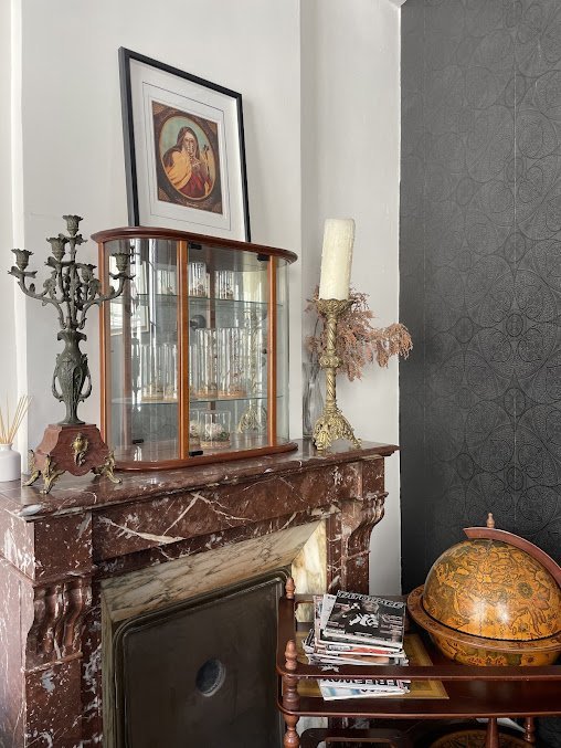 Coin salon de l'atelier Skull & Bones &mdash; chemin&eacute;e en marbre et cabinet de curiosit&eacute;s